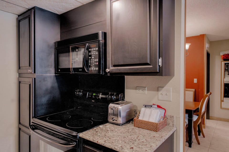 Kitchen with drip coffee pot, electric stovetop, toaster and more