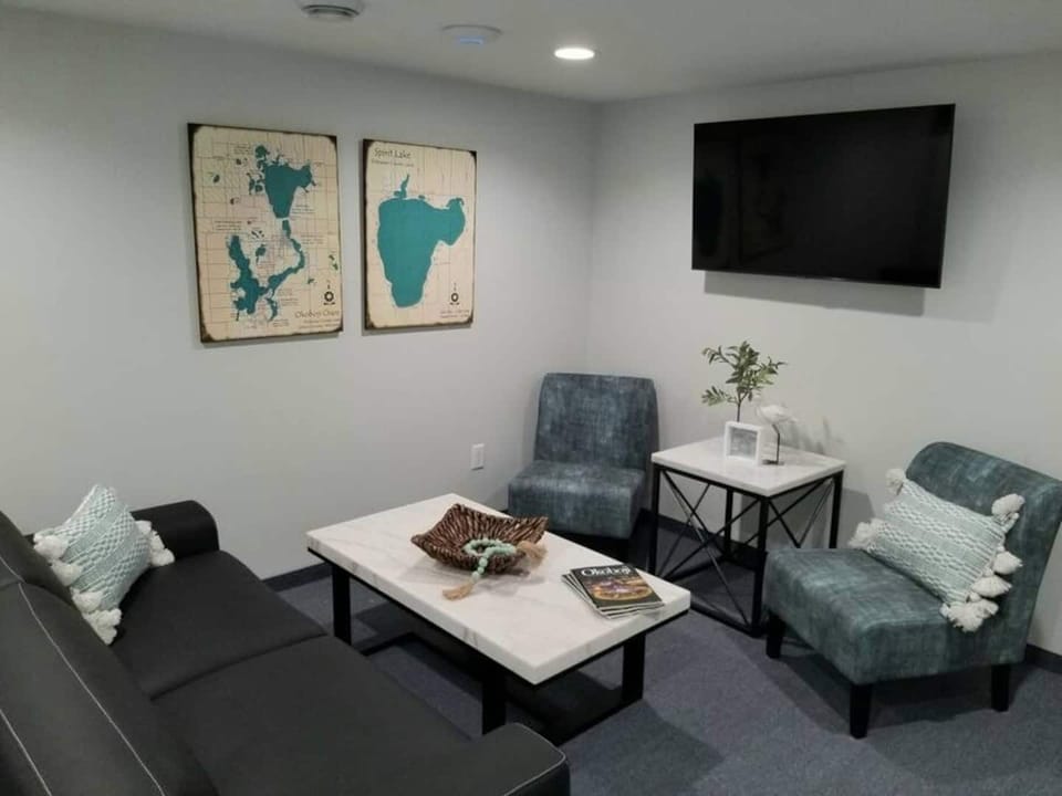 Living room area with smart tv, cable tv and wifi. A couch and 2 chairs.