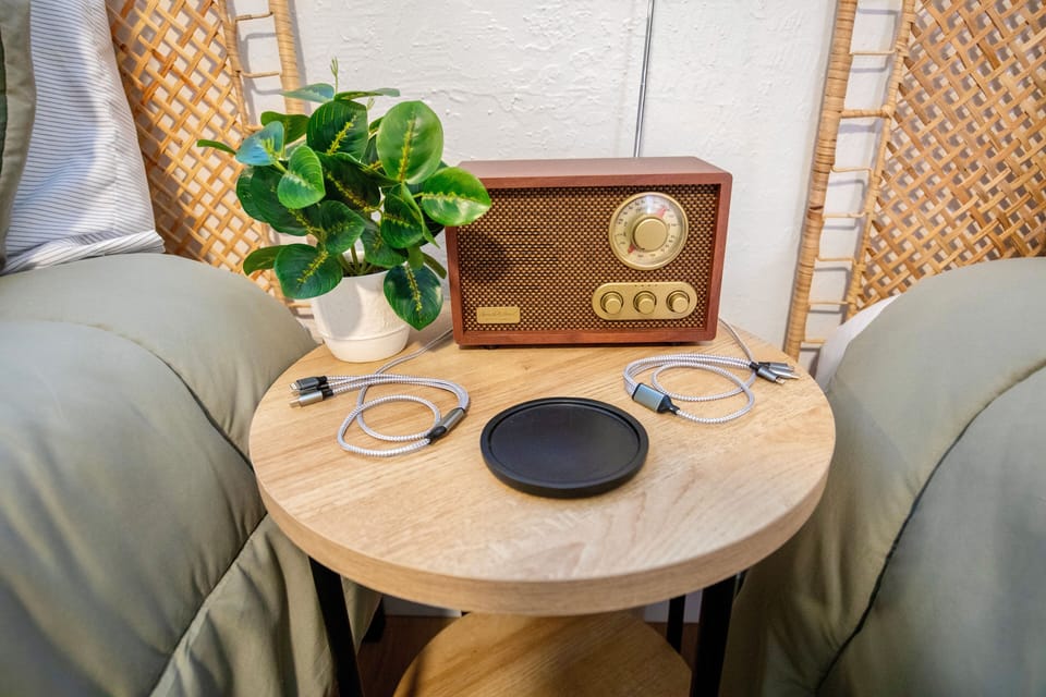 Phone chargers provided on side table  with fun retro style bluetooth/FM radio.