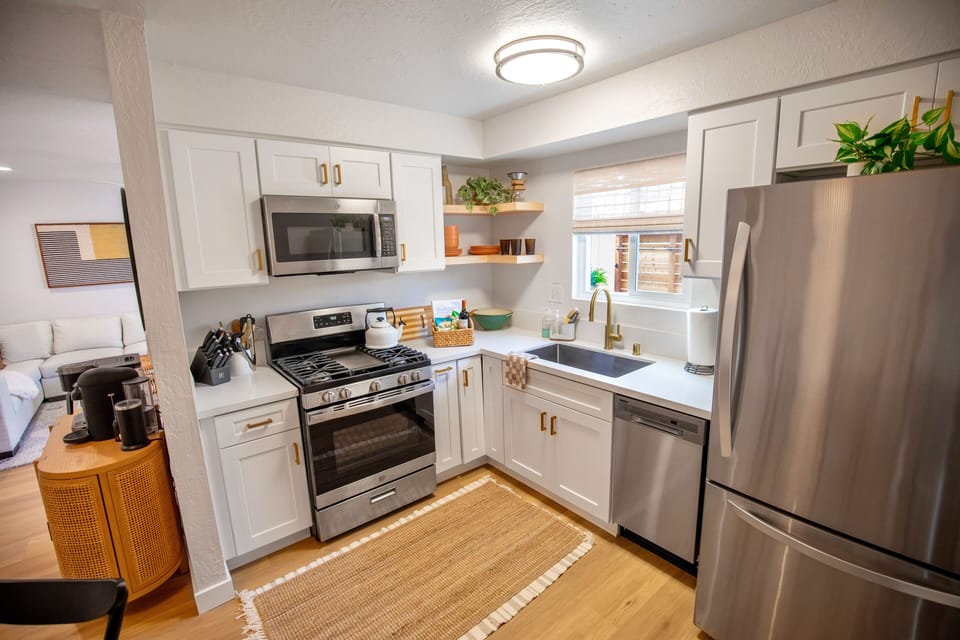 Newly remodeled kitchen with appliances, dishes, utensils and cooking supplies.