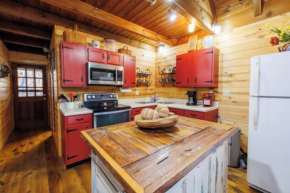 Bird`s Eye View – Fully equipped kitchen with stainless appliances and rustic red cabinetry.