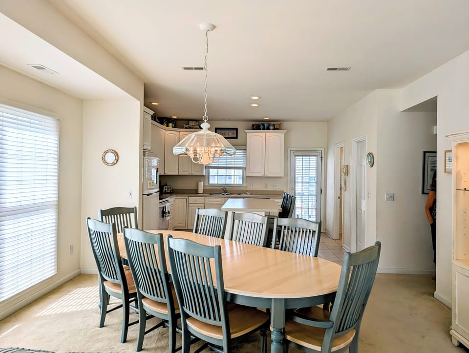 10 Dune Road (39544) - Dining Room & Kitchen - The dedicated dining area features a large wooden table with seating for the whole family. It is conveniently located just off the fully equipped kitchen, making mealtime a breeze during your stay.