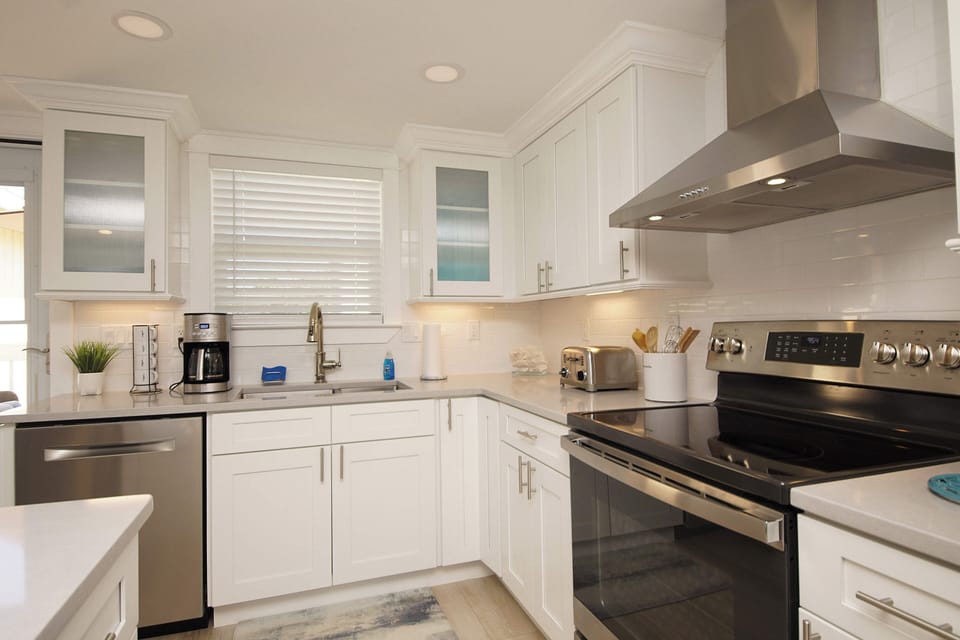 Prepare delicious meals in your fully-equipped kitchen featuring gleaming stainless steel appliances and bright white cabinetry.