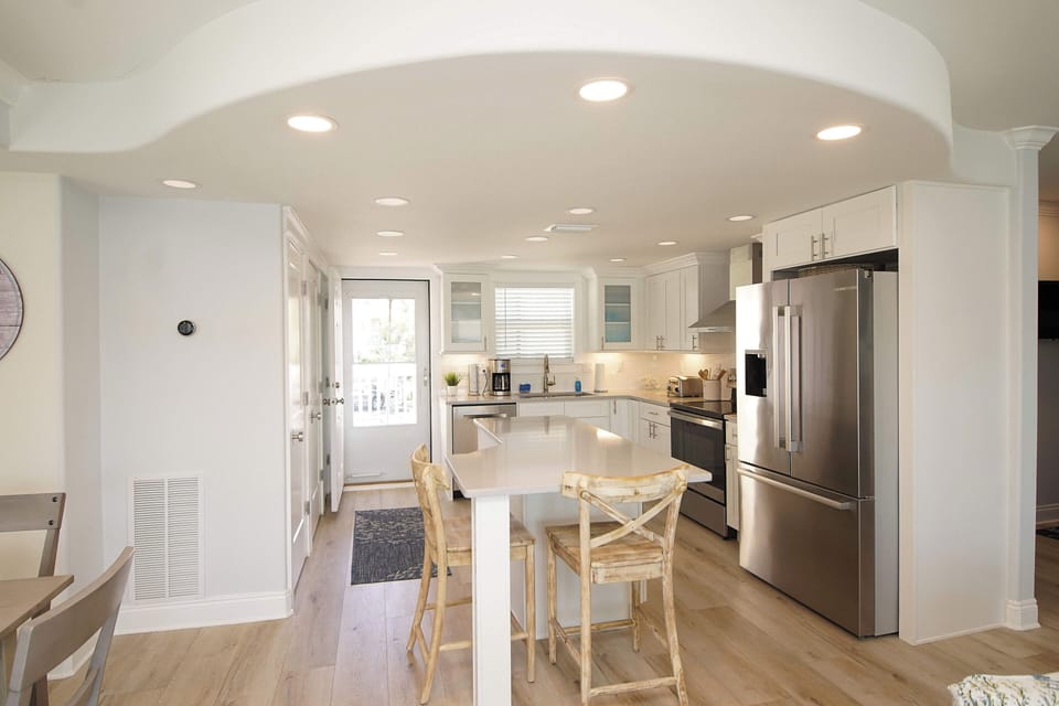 Your spacious kitchen features white cabinets, stainless appliances, and a cozy breakfast bar for morning coffee or casual meals.