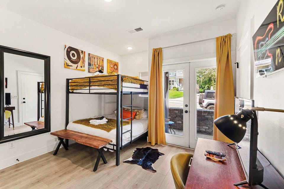 This 1st-floor bedroom includes queen-over-queen bunks, dedicated workspace, a private en suite and Stackable washer dryer