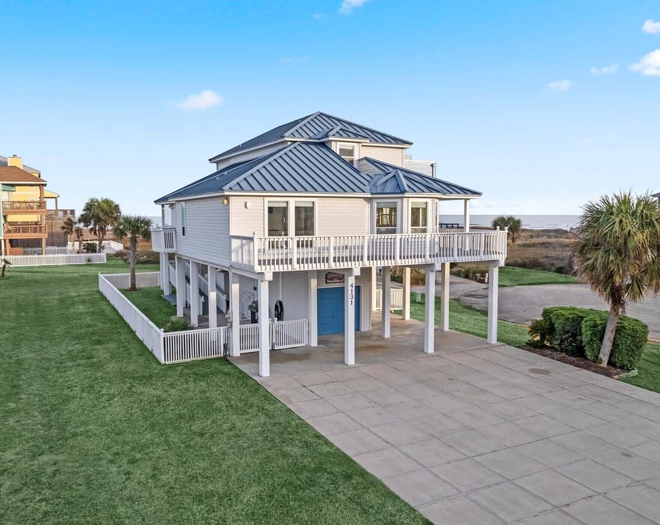 Quintessential beach house with a picturesque escape, capturing the essence of coastal charm from its pristine white picket fence and coastal blue tin roof to its soothing nautical interiors.