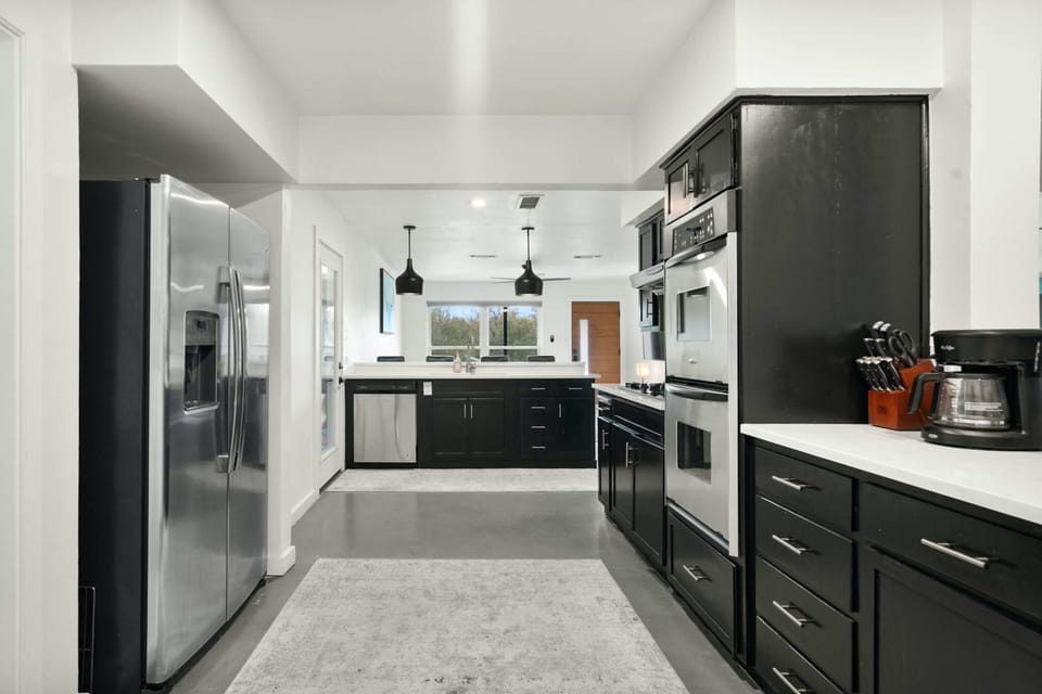 The sleek kitchen offers ample space & all the comforts of home