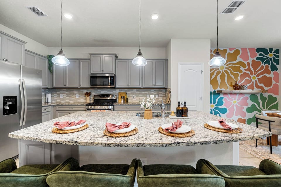 The kitchen is equipped with a kitchen island with bar seating for 4