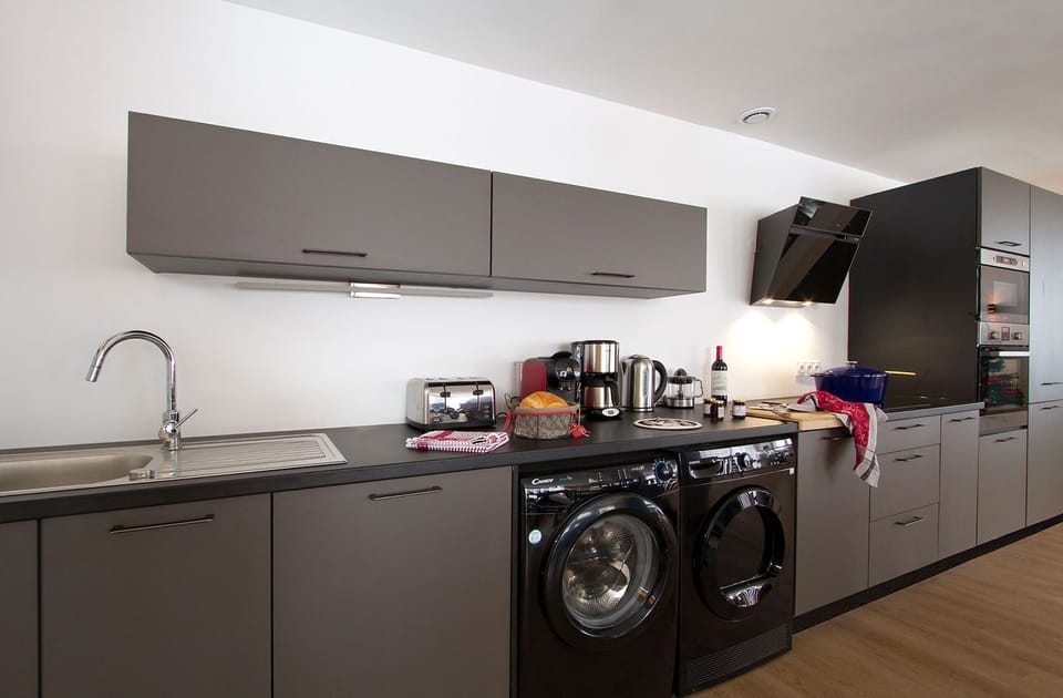 Whip up your favorite meals in this sleek, fully equipped kitchen with all the modern appliances you need, including a dishwasher and washing machine, for added convenience during your stay.