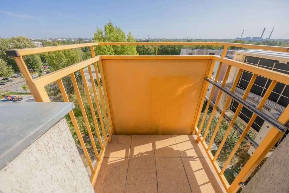 A small balcony with wooden flooring and railing. Ideal for enjoying fresh air and a bit of sunshine.