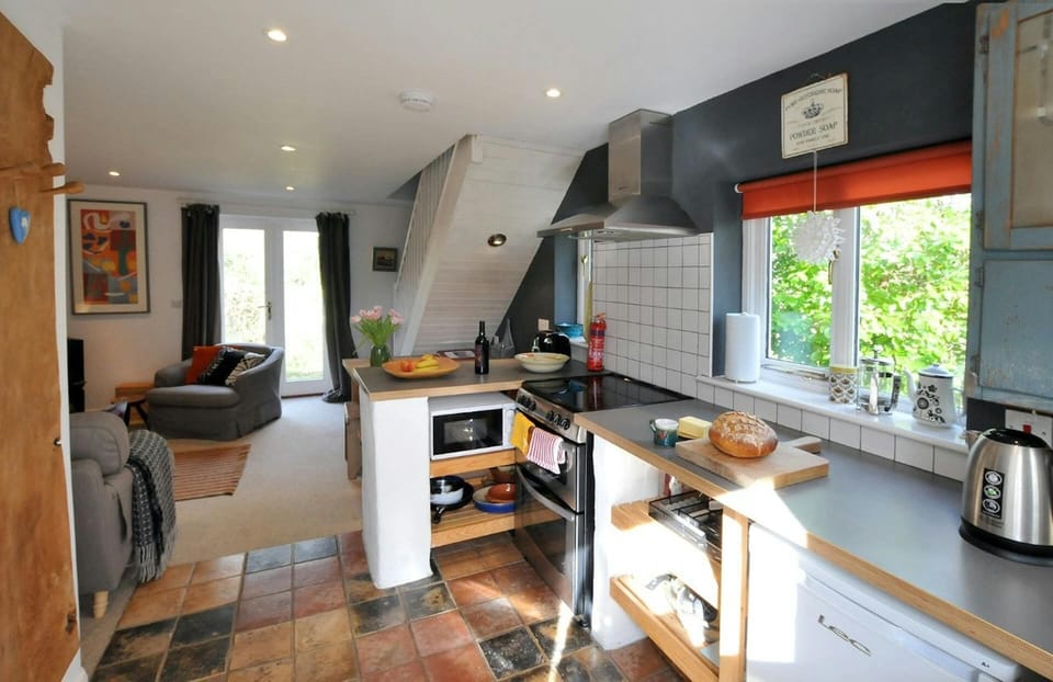 Kitchen with range cooker and cooker hood, microwave, kettle and fridge