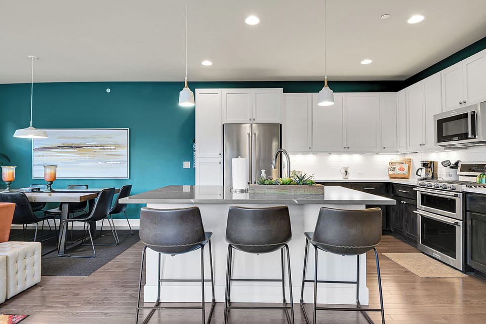 Large kitchen with working area and seating at the island that adds to the overall seating plan. An additional folding table with chairs and the island brings the total seating capacity to 15.