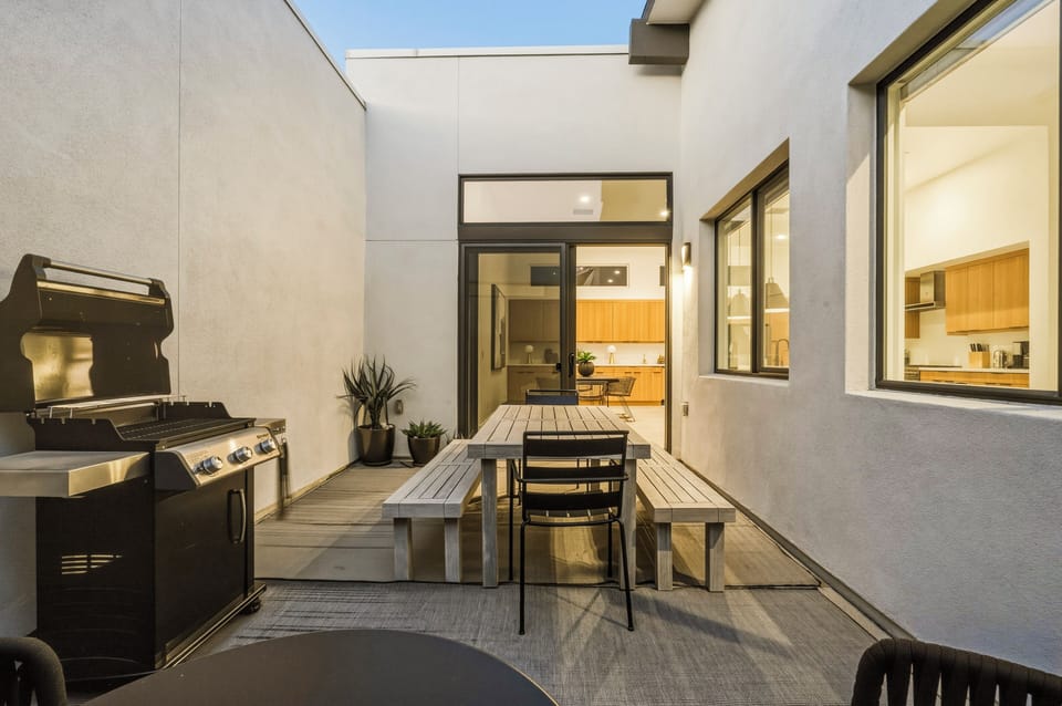 Private outdoor dining area and gas grill beneath the Palm Springs sky