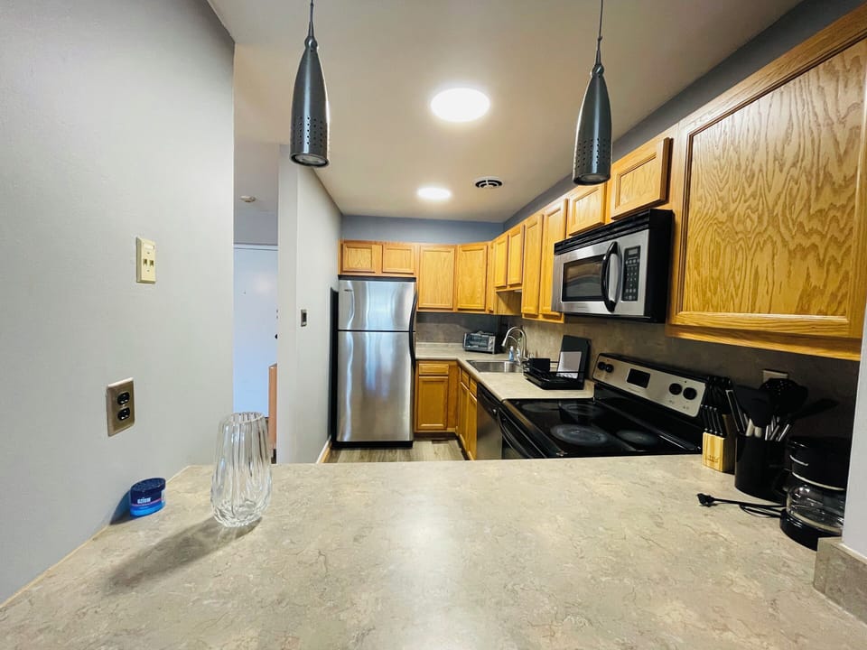 Designed for daily living, this kitchen offers a full-size fridge, range, spacious counters, and ample cabinets—everything you need, right where you need it.