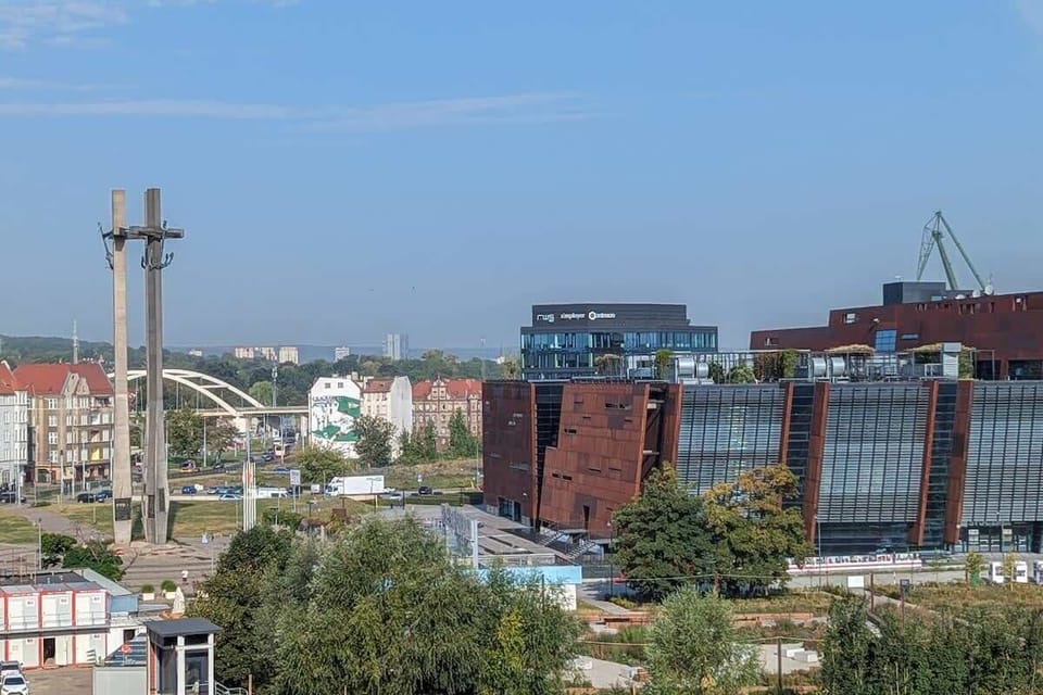 A scenic city view from the apartment with buildings and trees. A peaceful perspective from above.