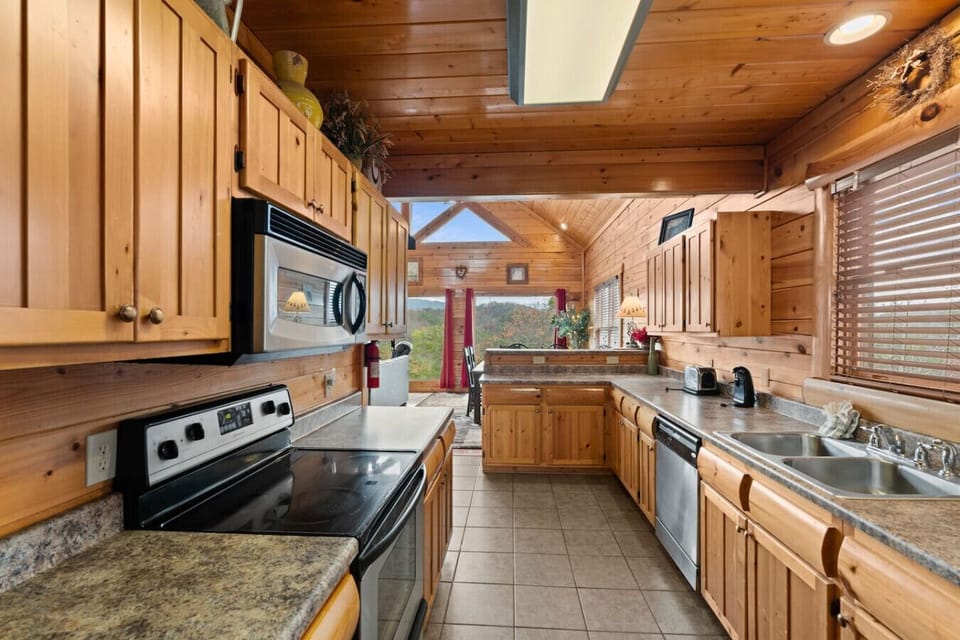 Enter the cabin through the fully-stocked kitchen. It includes a full suite of stainless steel appliances.