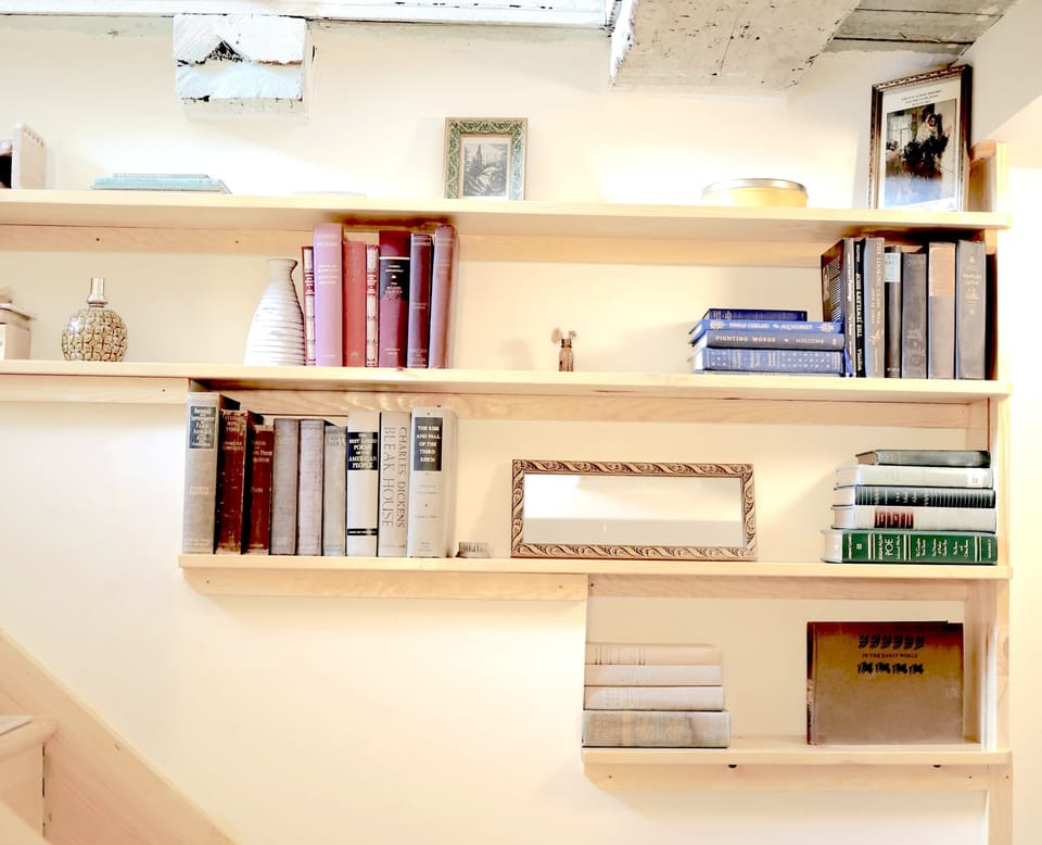 Curl up with a good book from your personal library collection, featuring beautifully organized shelves filled with diverse titles.