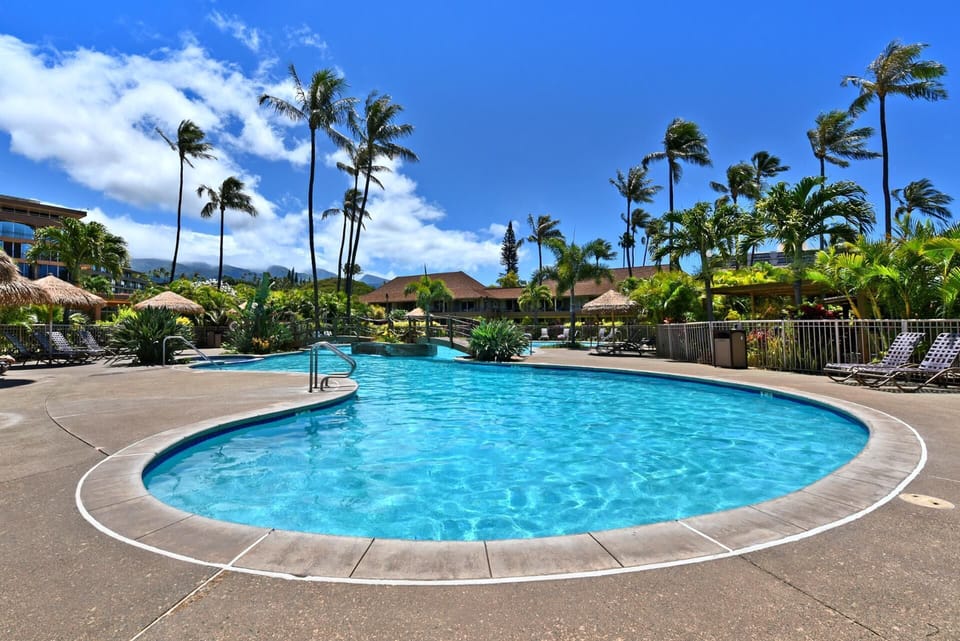 Resort-style pool oasis surrounded by tropical gardens, swaying palms & crystal-clear tranquil waters