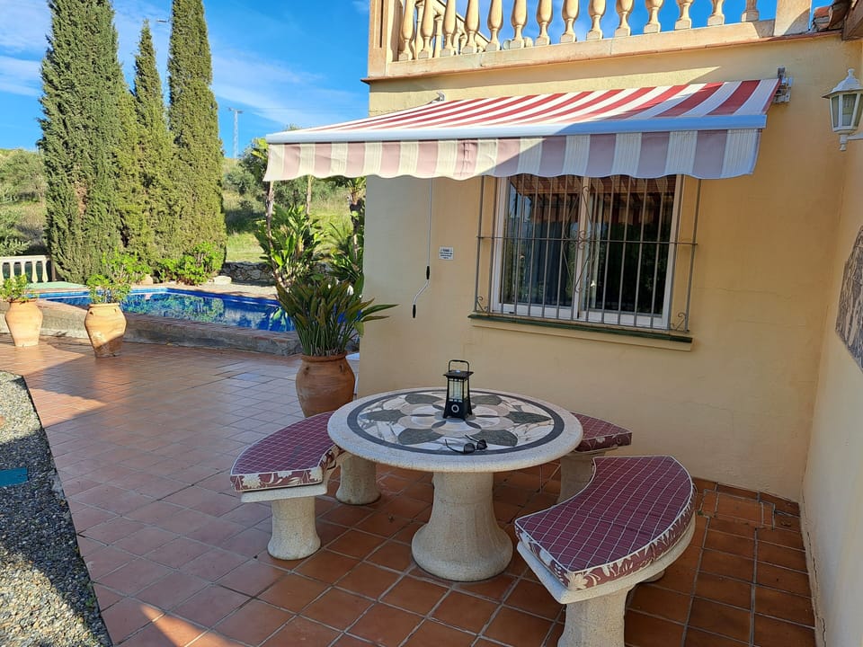 Covered shady,seating for 6 close to BBQ for outside dining. Roof terrace above.