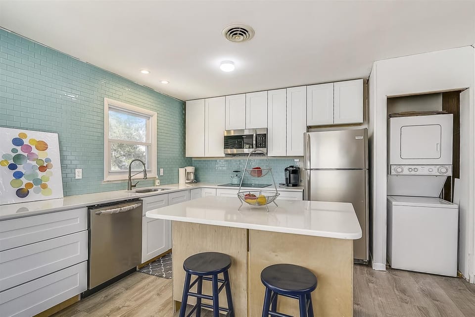 Your bright, fully-equipped kitchen awaits, complete with modern appliances and a welcoming island for meal prep or casual dining.