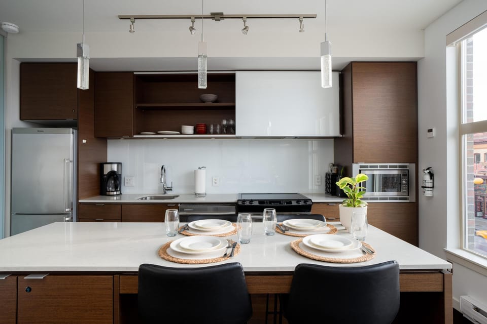 Channel your inner chef in a premium kitchen with sleek two-tone cabinetry, a large central island, and modern stainless steel appliances.