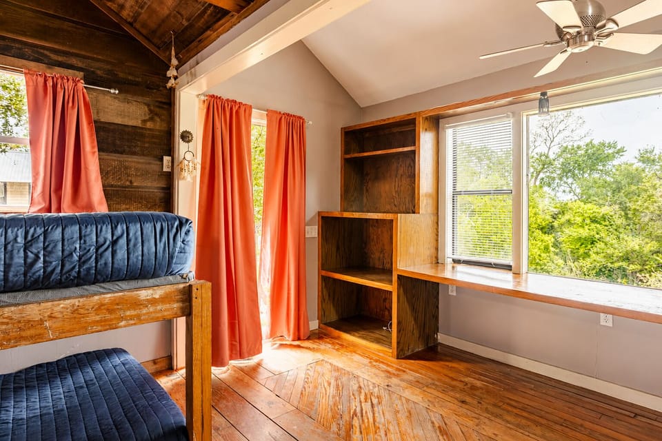 Cozy rustic bunk loft with treetop views, built-ins, and bright natural light