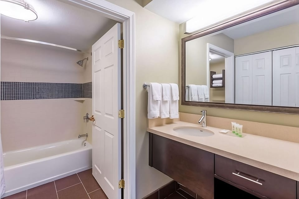 Refresh comfortably with a bright vanity and shower-tub combo.
