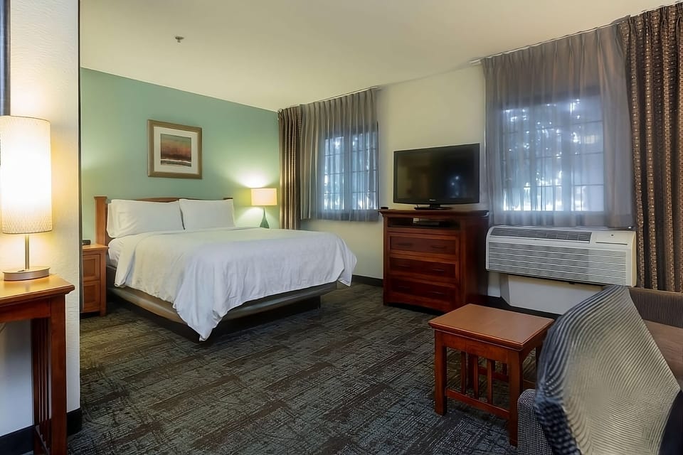 Unwind in a spacious bedroom with TV and plush seating.