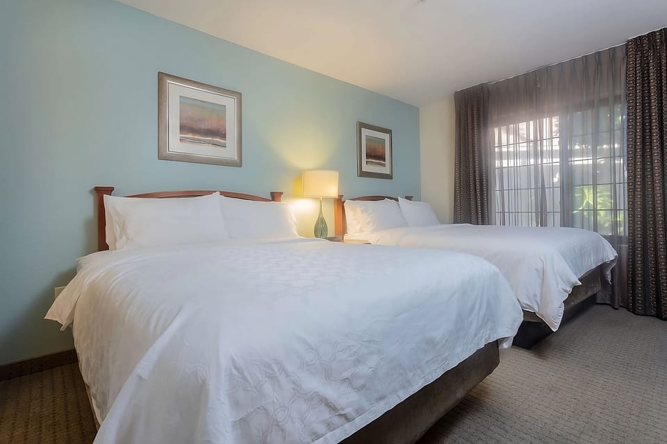 Recharge on crisp linens in a calm, spacious two-bed room.