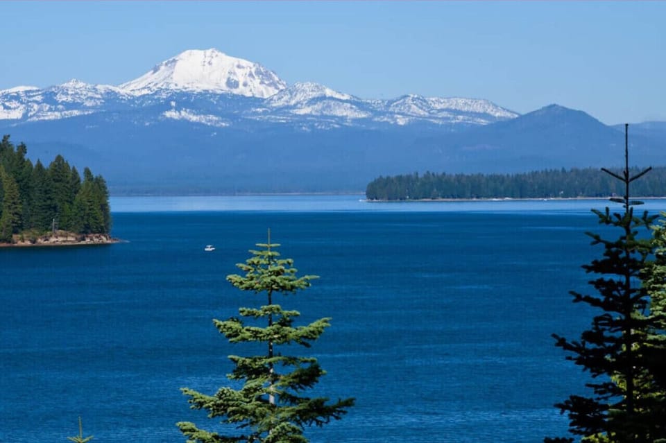 Breathtaking view of Lake Almanor with crystal-clear waters and snow-capped Mount Lassen in the distance — a nature lover’s paradise for boating, fishing, and year-round adventure.