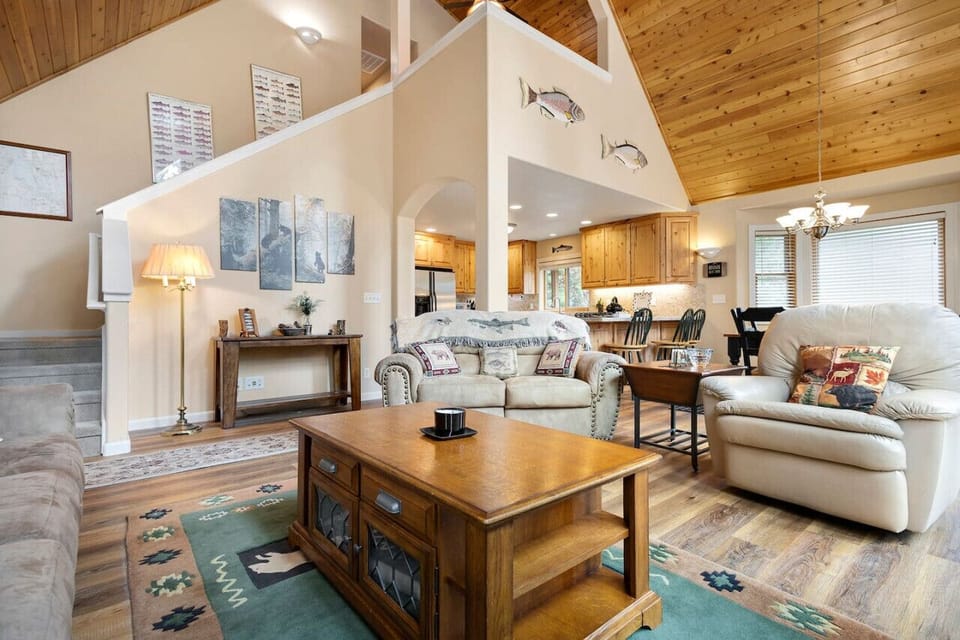 Warm and inviting open-concept living space with vaulted wood ceilings, rustic decor, and plenty of natural light — ideal for relaxing or entertaining near Lake Almanor.