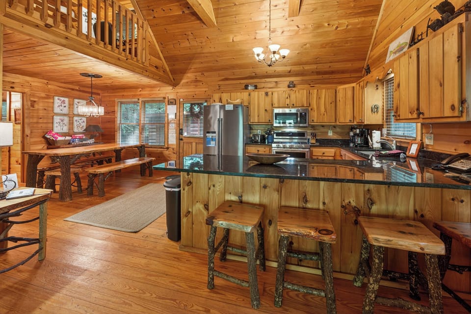 Rustic kitchen with wooden cabinetry and breakfast bar, perfect for cozy cabin meals.