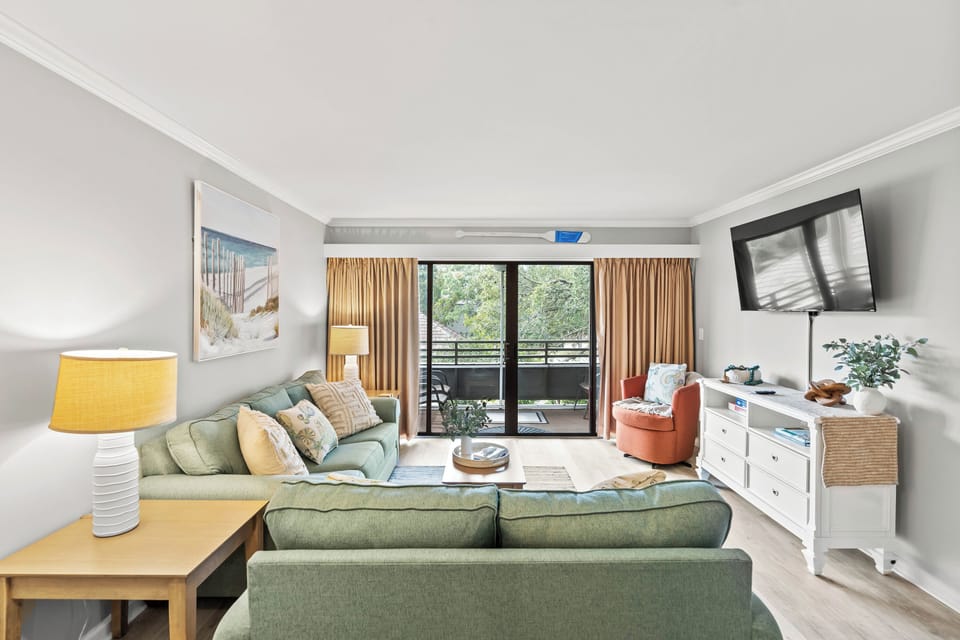 A bright and inviting living room with cozy seating and a TV for comfort.