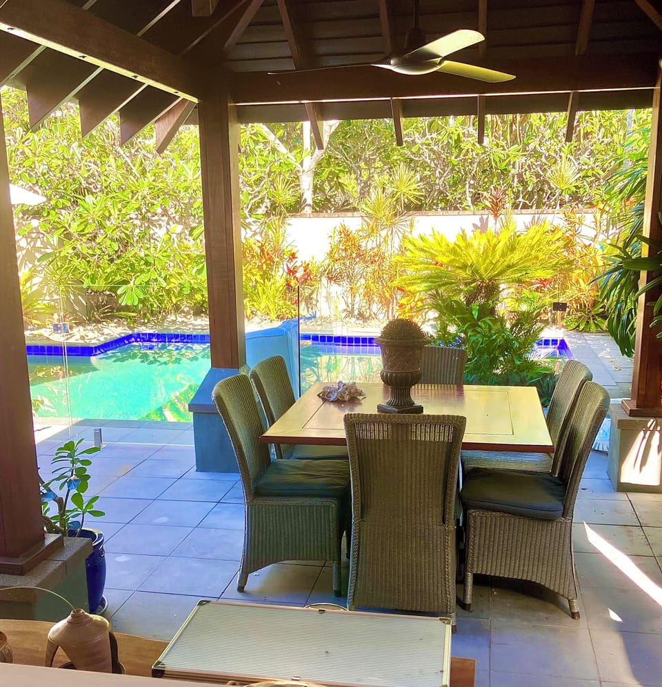 English wicker dining chairs in the dining pavilion next to the pool
