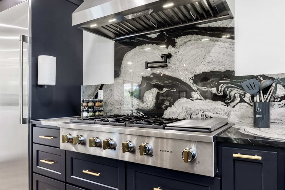 Cook like a chef in this modern kitchen equipped with top-of-the-line appliances and a stunning backsplash.