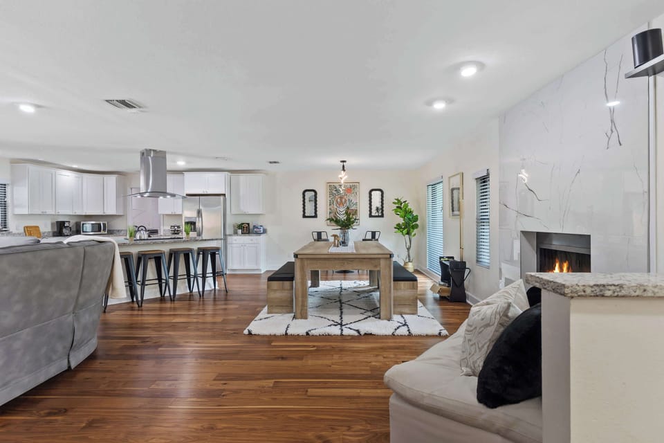 Gather in this inviting open-concept space featuring a stylish dining area, modern kitchen, and cozy fireplace—perfect for making memories with family and friends.