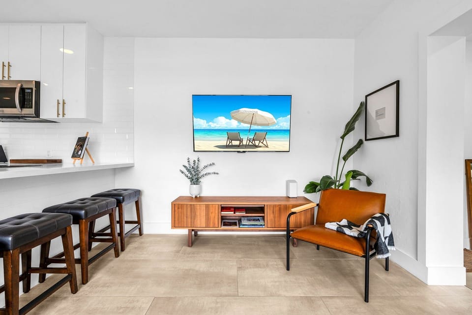 Open floorplan features a living room, dining for 6, smart streaming 65" TV, and access to the kitchen.