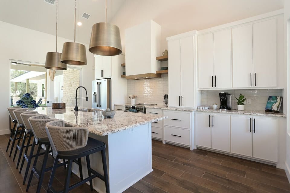 Modern kitchen with a large island, bar seating, and high-end stainless appliances.