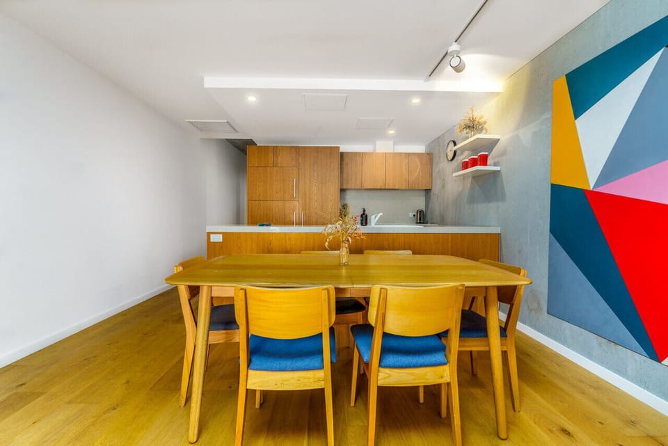 Spacious dining area with a 6-seater table, complemented by stylish artwork, creating a chic and welcoming atmosphere for meals and gatherings.
