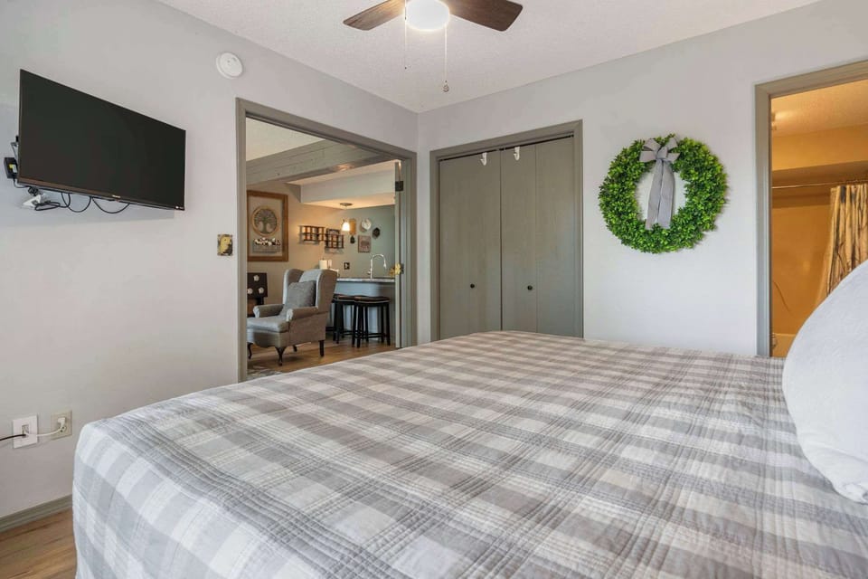 Bedroom 2 with King bed, TV, deck access, and private en-suite