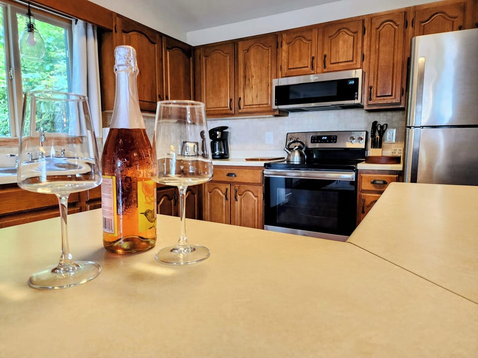 Open kitchen with stainless appliances, island seating & connected dining/living