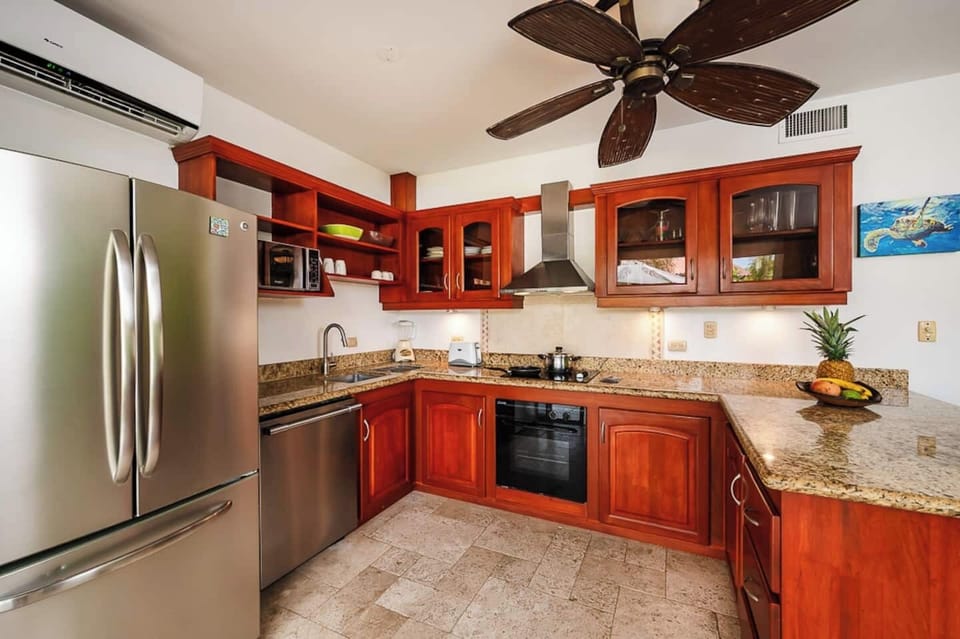 Fully equipped kitchen with modern appliances and stylish furnishings, designed for preparing meals with ease while staying connected to the dining and living areas of this Langosta Beach condo in Tamarindo.