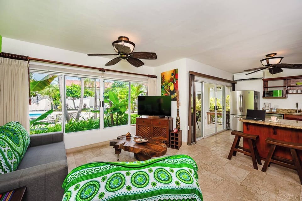 Spacious living area featuring modern furnishings and panoramic windows, offering a relaxing environment to unwind while enjoying views of the tropical surroundings in Langosta Beach.