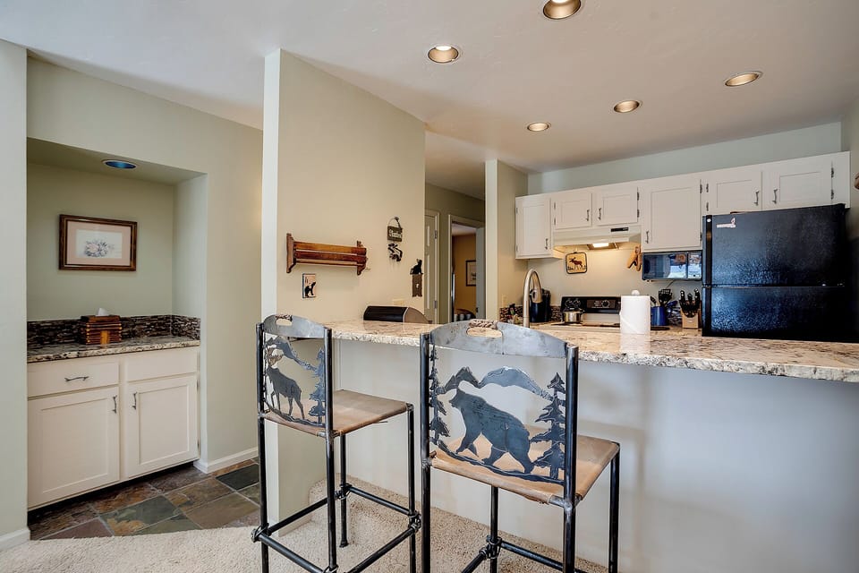 Gather around your well-appointed kitchen island for morning coffee or evening conversations, featuring granite countertops and rustic wildlife-themed seating.