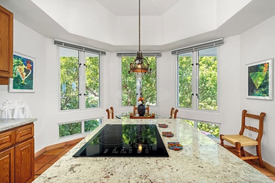 Island, flat stove-top
Kitchen has a Dining Nook which seats four on wood-and-rattan chairs, around a glass-top table – right next to panorama windows offering a lush garden view.