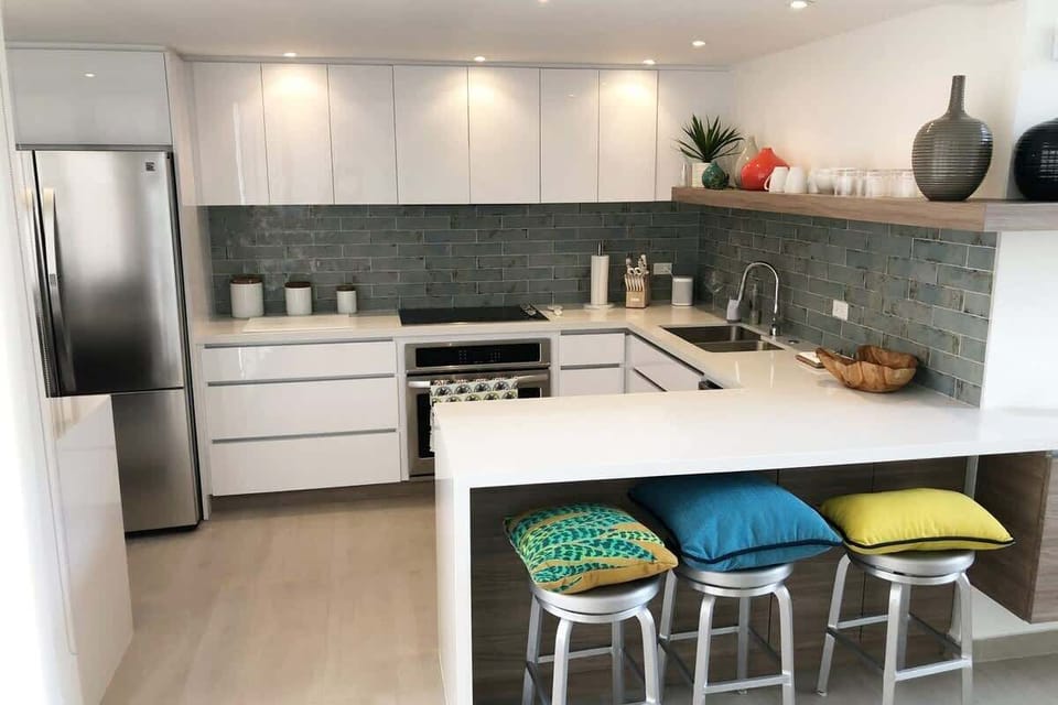 Three-bar stool service countertop
Flat-top stove
Conventional oven
Double-door refrigerator with ice maker
Dishwasher
Double sink
Wine Cooler