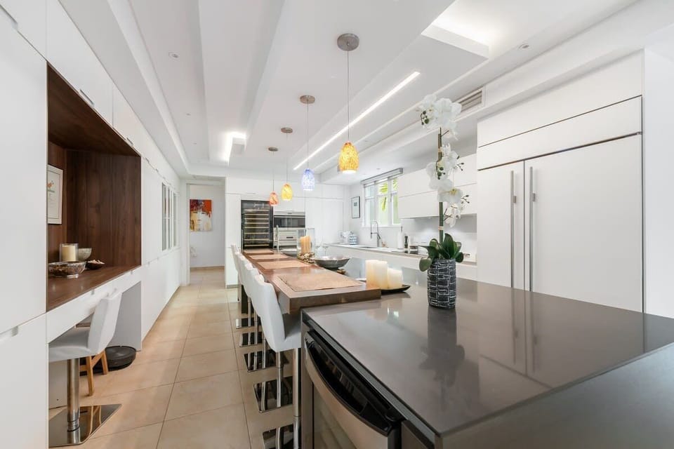 Adjacent to the living room in one continuous space, the dining area seats eight on
upholstered dining room chairs around a custom-made dining table.