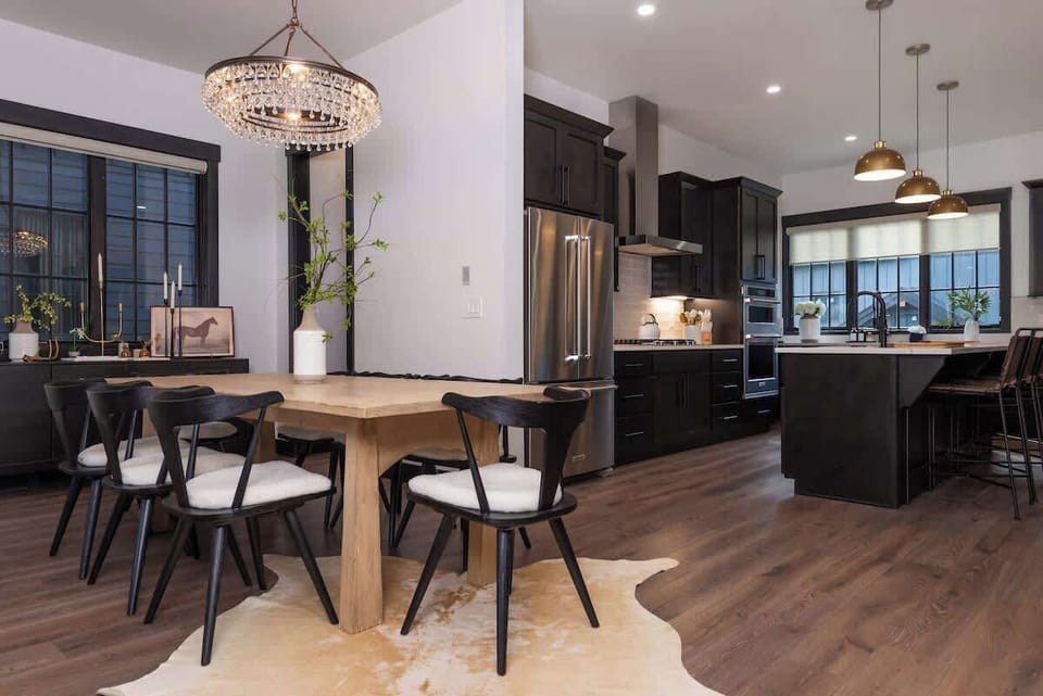 - Share meals around a cozy wood table under a glowing rustic chandelier
- The open plan design blends kitchen and dining for effortless hosting
- Natural textures and stylish tones create a warm, modern mountain vibe