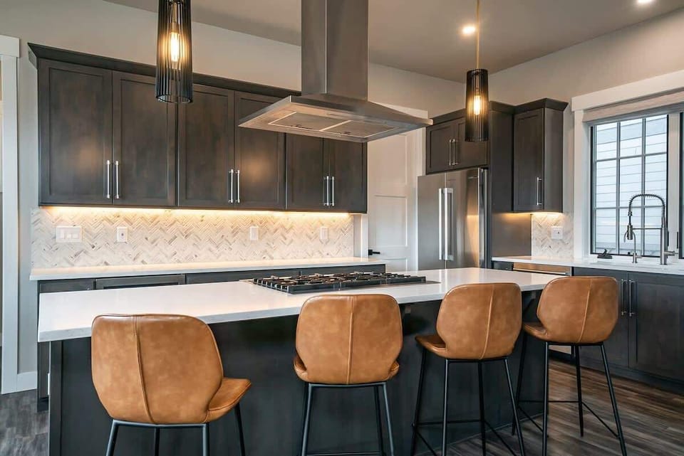 - Sleek cabinetry, essential appliances, & a designer backsplash bring modern elegance to your cooking space
- Gather around the spacious island with leather stools for casual meals and conversation
- Designed to inspire, from prep to plating