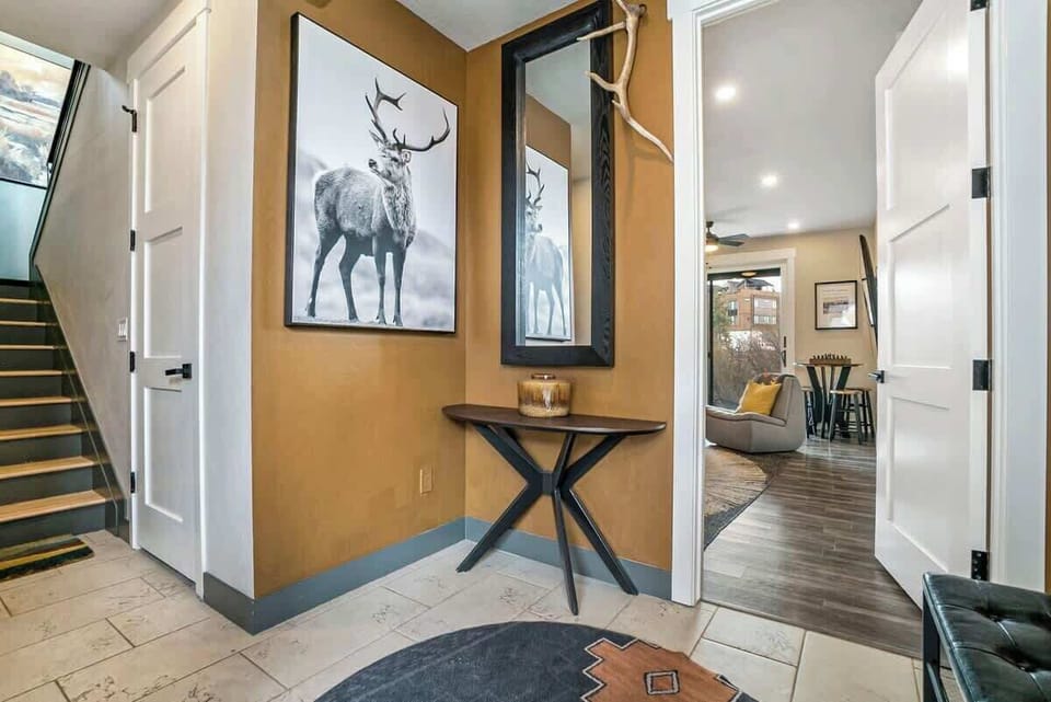 - Enter through a bold hallway featuring wildlife inspired artwork, natural tones, and textured accents
- Sleek mirror and console table offer both function and style
- Warm welcome that sets the tone for your elevated mountain stay